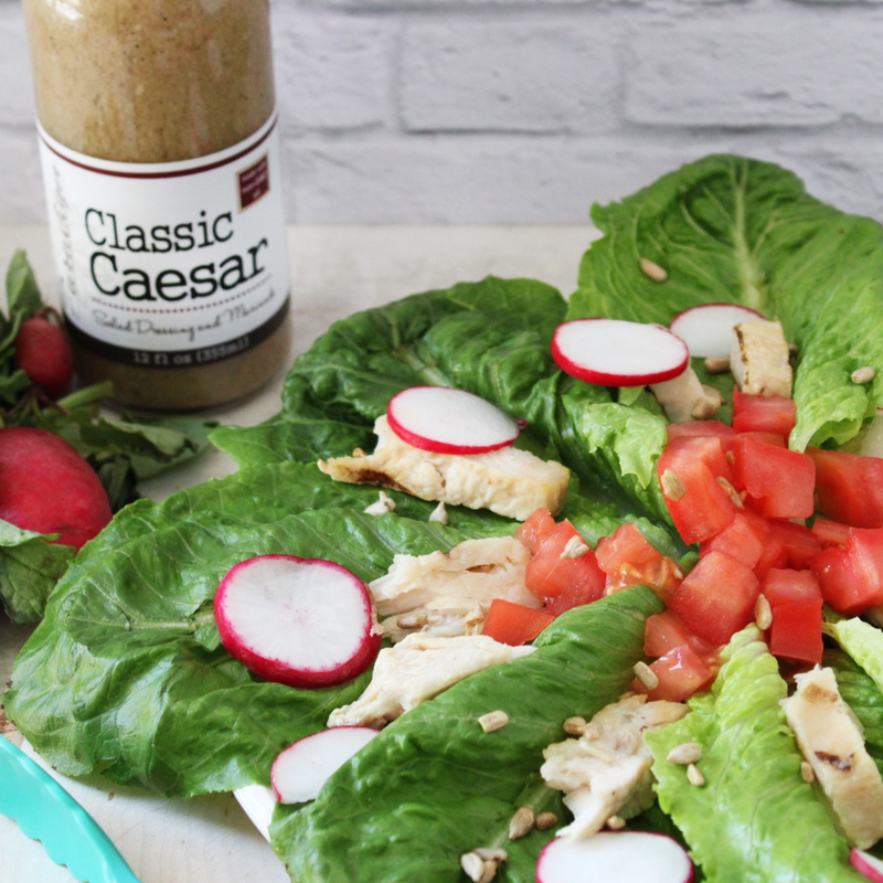 Romaine Lettuce with radishes, chicken, chopped tomatoes and sunflower seeds topped with Paradigm Foodworks Classic Caesar Dressing 