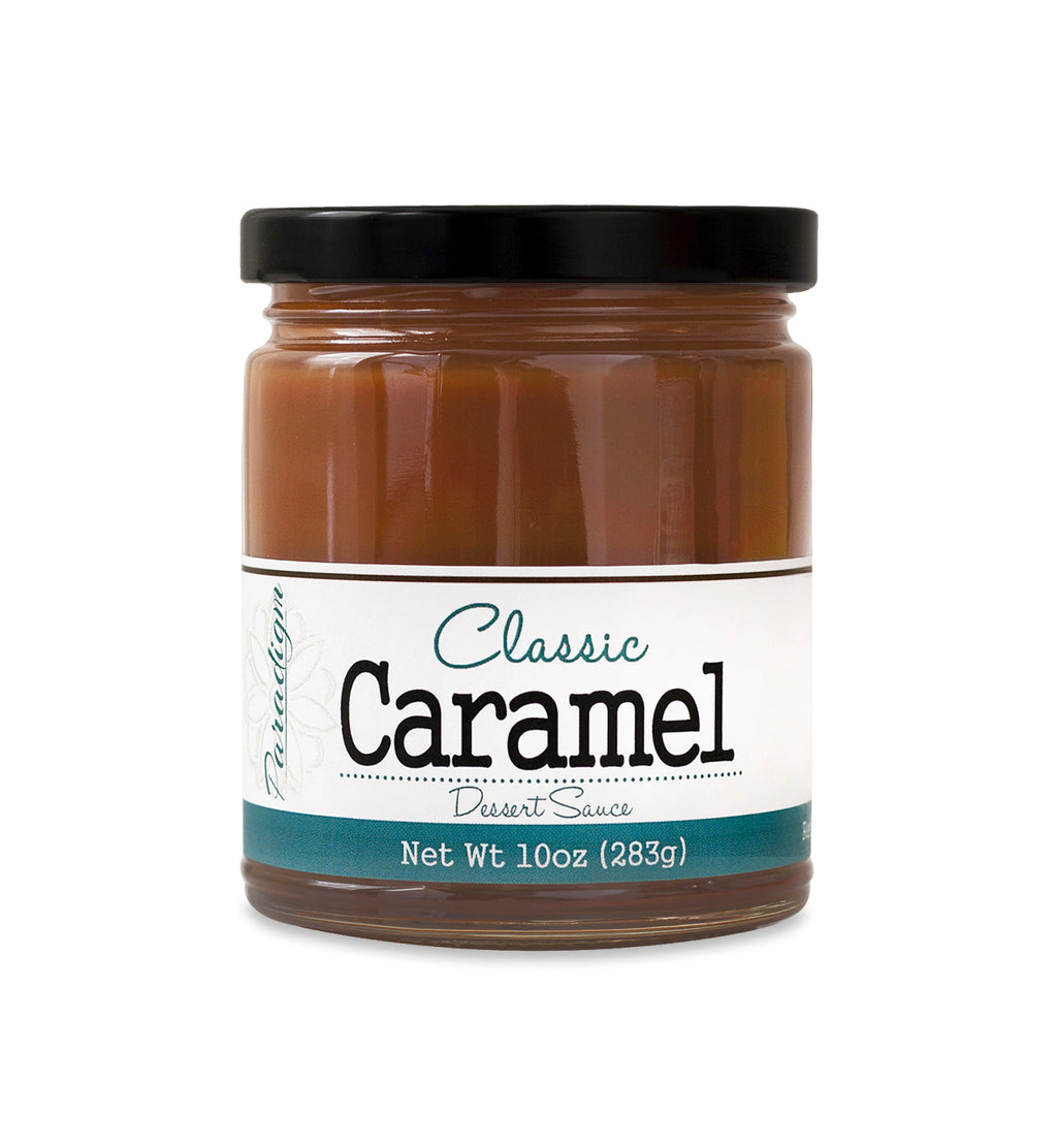Short, lidded jar full of caramel sauce, on white background. The jar is labeled “Paradigm Classic Caramel Dessert Sauce – Net Weight 10oz (283g)”