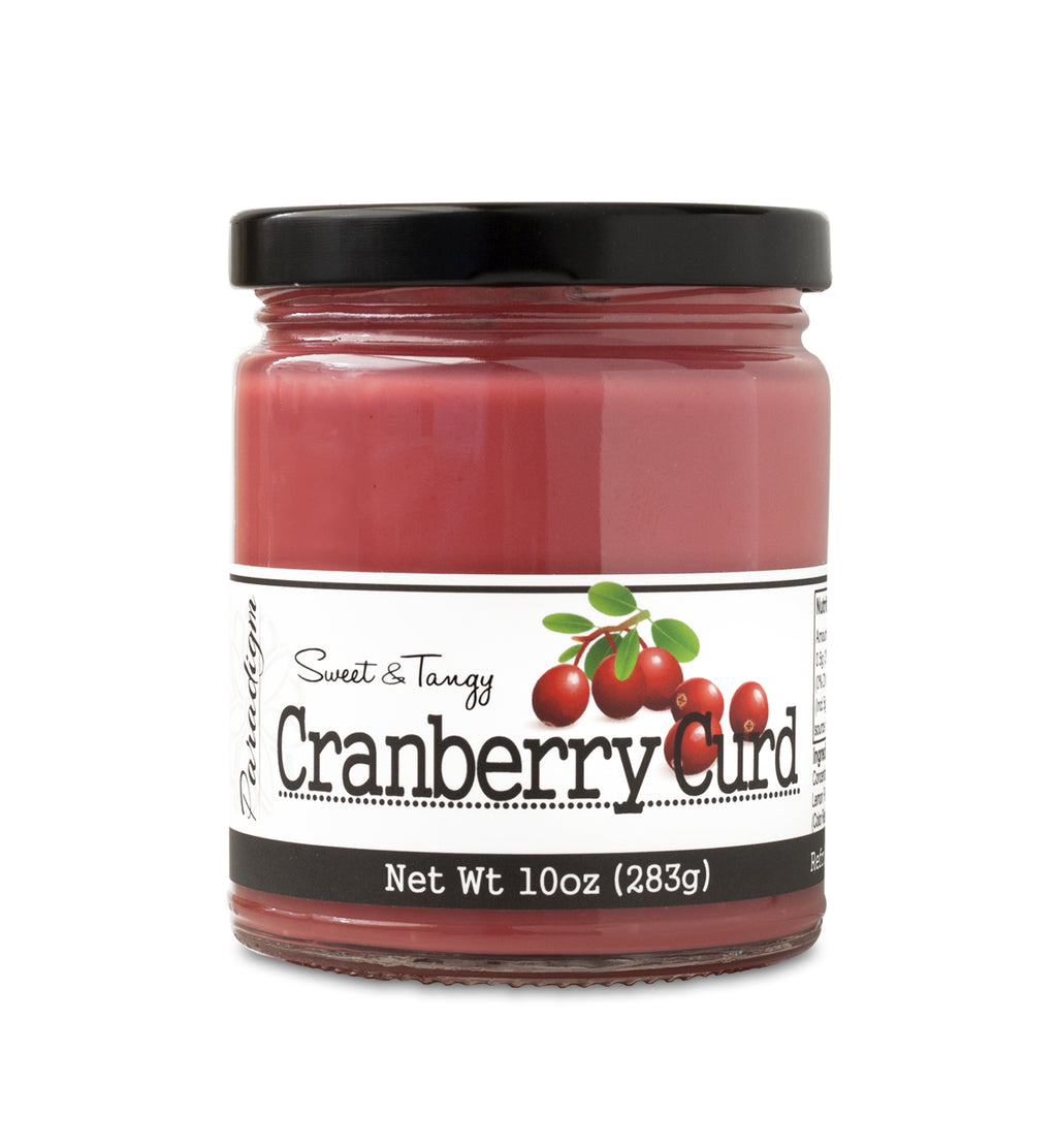Short, lidded jar full of Cranberry Curd, on white background. The jar is labeled “Paradigm Sweet & Tangy Cranberry Curd– Net Weight 10oz (283g)” 