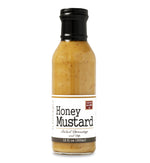 Glass ring neck bottle filled with Honey Mustard on white background. The bottle is labeled, “Paradigm Honey Mustard Salad Dressing and Dip – 12 fl oz (355 ml)”.