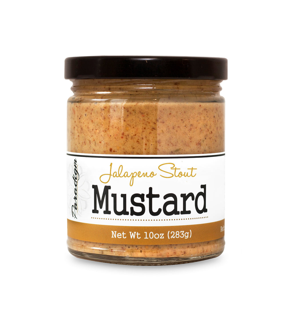 Short, lidded jar full of jalapeno stout mustard on white background. The jar is labeled, “Paradigm Jalapeno Stout Mustard – Net Weight 10oz (283g)”