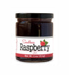 Short, lidded jar full of raspberry jam, on white background. The jar is labeled “Paradigm Seedless Raspberry Jam – Net Weight 11oz (311g)”