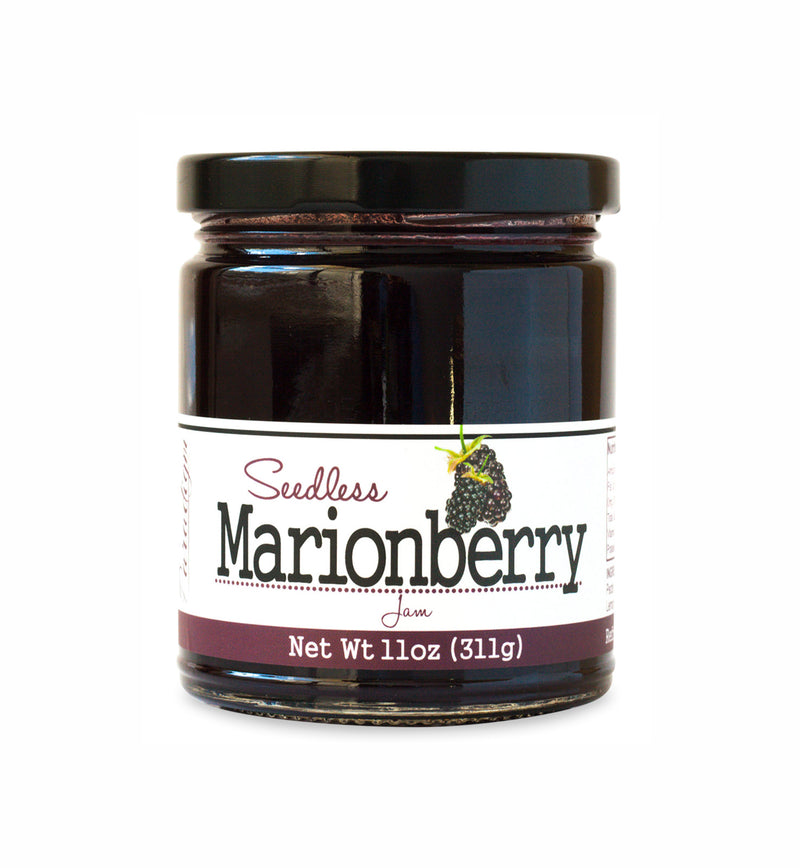 Short, lidded jar full of marionberry jam, on white background. The jar is labeled “Paradigm Seedless Marionberry Jam – Net Weight 11oz (311g)” 
