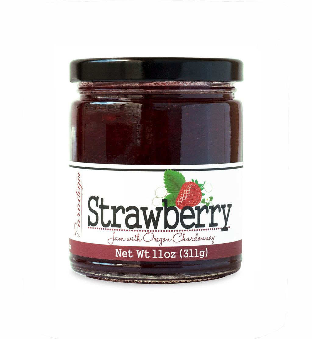 Short, lidded jar full of strawberry jam, on white background. The jar is labeled “Paradigm Strawberry Jam with Oregon Chardonnay – Net Weight 11oz (311g)”