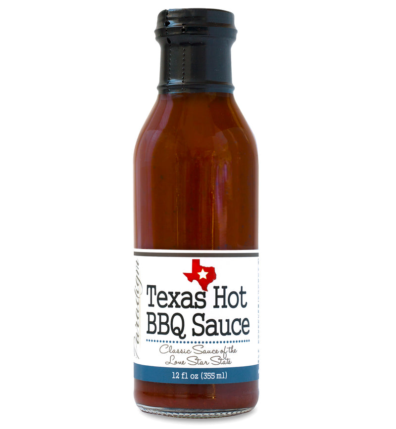 Glass ring neck bottle filled with BBQ sauce on white background. The bottle is labeled, “Paradigm Texas Hot BBQ Sauce – Classic Sauce of the Lone Star State – Made with Oregon Stout & Coffee – 12 fl oz (355ml)”