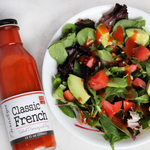 Mixed greens salad with avocados and chopped tomatoes topped with Paradigm's Classic French Dressing