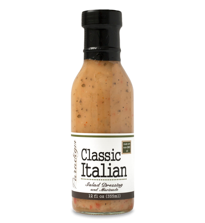 Glass ring neck bottle filled with Classic Italian dressing on white background. The bottle is labeled, “Paradigm Classic Italian Salad Dressing and Marinade – 12 fl oz (355ml)”.